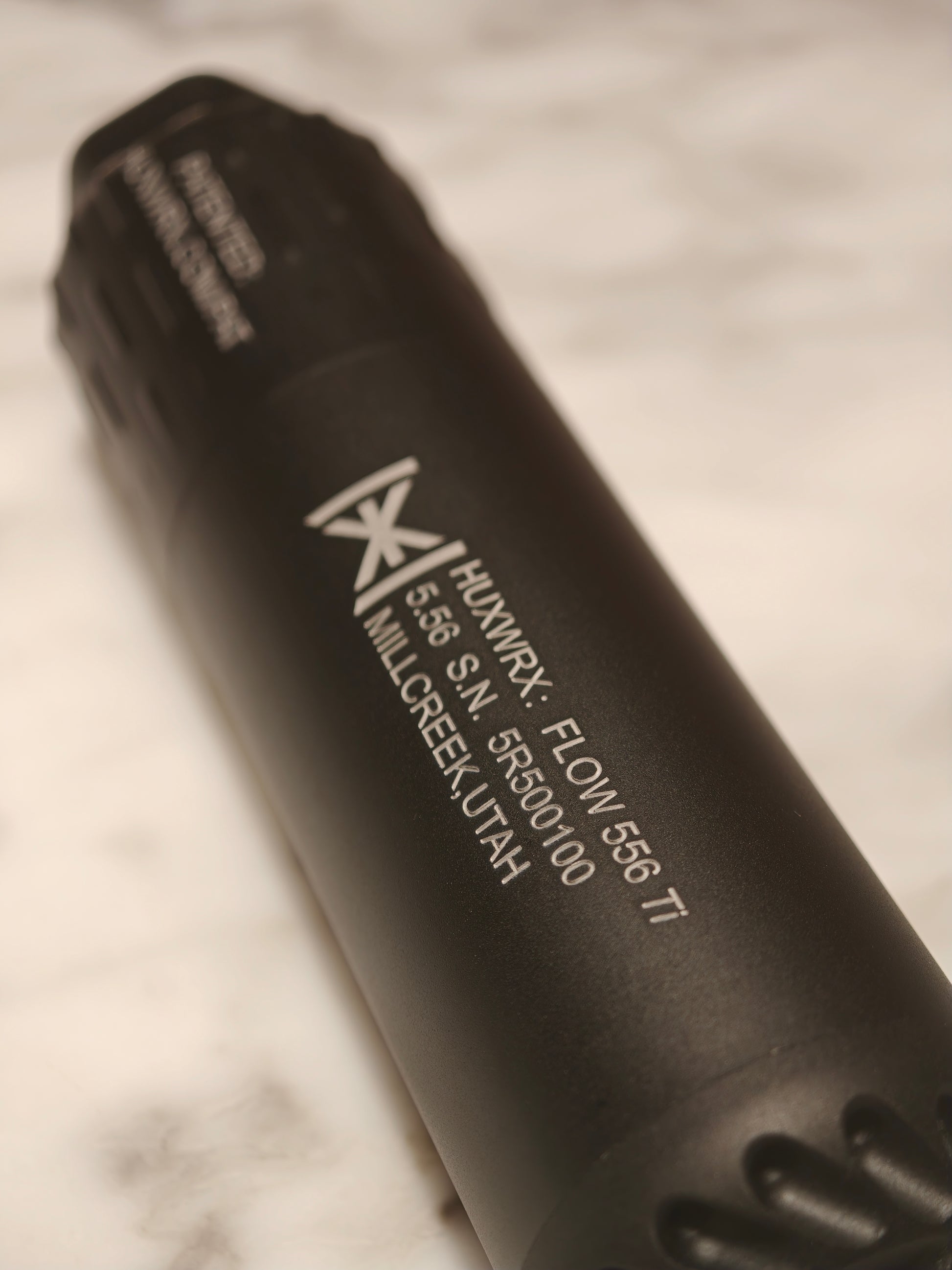 HUXWRX FLOW 556Ti engraved markings and textured front section close-up